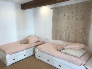 2 łóżka w pokoju z białymi ścianami w obiekcie Casa La Marina w mieście Hondarribia