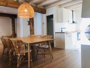 Un comedor con mesa y sillas de madera. en Casa La Marina, en Hondarribia 11 fotos más