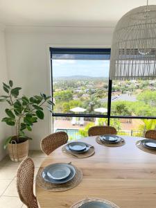 une table à manger avec des chaises et une grande fenêtre dans l'établissement Gold Coast uninterrupted uphill view & big pool, à Gold Coast