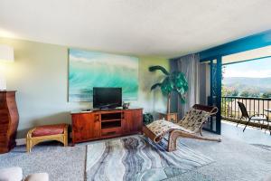 a living room with a tv and a chair at Hanalei Bay Resort 6222 in Princeville