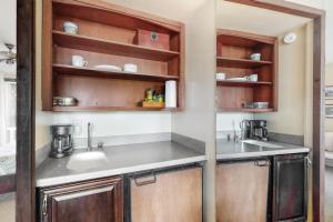 una cocina con armarios de madera y fregadero en Hanalei Bay Resort 9204 en Princeville