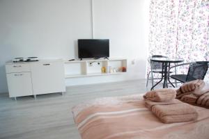 een witte woonkamer met een tv en een bank bij Cavleski rooms in Prilep