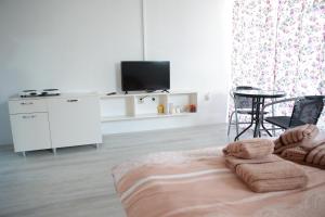 a white living room with a tv and a couch at Cavleski rooms in Prilep