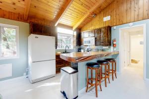 a kitchen with a white refrigerator and bar stools at Running Springs Sanctuary in Running Springs
