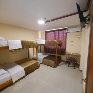 Zimmer mit 2 Etagenbetten und einem Fenster in der Unterkunft Hotel Bonanza in Guayaquil