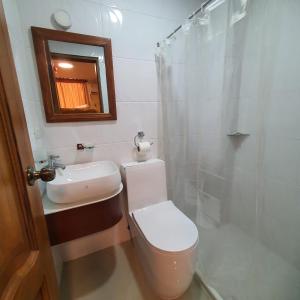 a bathroom with a toilet and a sink and a mirror at Hotel Bonanza in Guayaquil