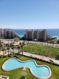 an aerial view of a resort with a swimming pool and the ocean at Departamento familiar in Algarrobo