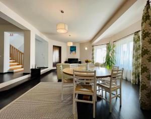 a dining room and living room with a table and chairs at Hermesvilla in Baile Felix