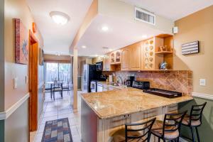 a kitchen with a counter and some chairs in it at Escape to the Keys in Islamorada