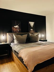 um quarto com uma cama grande e paredes pretas em Shadow Sleep em Schonungen