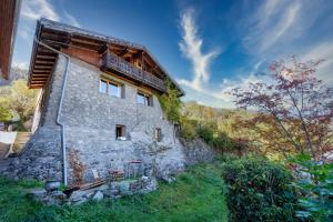 una antigua casa de piedra con un balcón en el lateral. en Magnifique chalet authentique au cœur des 3 vallées en Courchevel