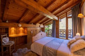 sypialnia z łóżkiem w pokoju z drewnianymi ścianami w obiekcie Magnifique chalet authentique au cœur des 3 vallées w Courchevel