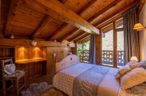a bedroom with a bed in a room with wooden walls at Magnifique chalet authentique au cœur des 3 vallées in Courchevel