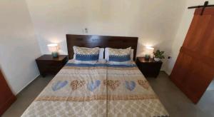 1 dormitorio con 1 cama con colcha de corazones en Casita Amarilla, en Santa Cruz