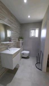 ein Badezimmer mit einem weißen Waschbecken und einem WC in der Unterkunft Casita Amarilla in Santa Cruz