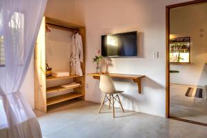 a room with a desk and a chair and a mirror at Casa Jenipapo Trancoso - Sinta o pedacinho do céu in Trancoso