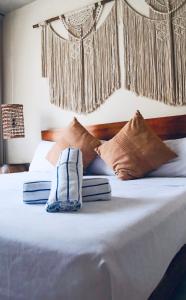 a bed with brown and white pillows on it at Casa Azul 2 BedBath in Tulum
