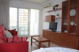 a living room with a red couch and a tv at Gemelos 22 - Zand Properties in Benidorm