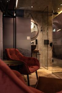 a bathroom with a red chair and a shower at The Heritage Boutique Accommodation in Rabat
