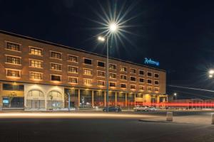 a building with a street light in front of it at Radisson Blu Hotel, Buraidah in Buraydah