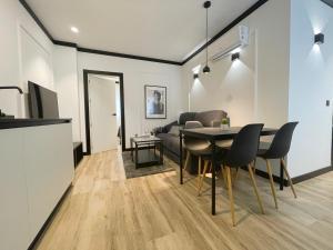 a dining room and living room with a table and chairs at Apartamentos MK77 León - Lancia in León