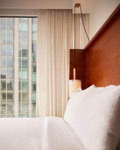 - une chambre avec un lit blanc et une fenêtre dans l'établissement Arlo NoMad, à New York