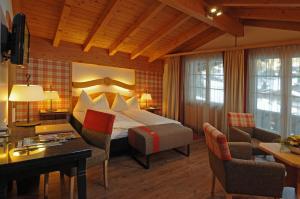 Habitación de hotel con cama y escritorio en Hotel Kirchbühl Superior, en Grindelwald