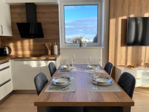 comedor con mesa, sillas y ventana en Apartment Petra Klinovec, en Loucná pod Klínovcem