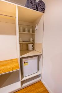 a cupboard in a kitchen with a door open at The Silverton Hotel in Silverton