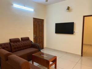 uma sala de estar com um sofá e uma TV na parede em Pullad em Aranmūla