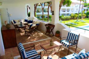 an outdoor patio with chairs and a couch and a table at Apartment in El Presidente Beach Side New Golden Mile in Estepona