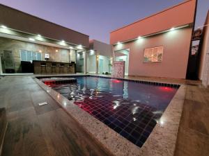 a swimming pool in a house with a building at CASA ARUANÃ 5 SUITES in Aruanã