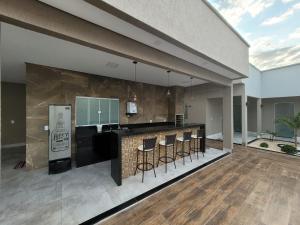 a kitchen with a counter and bar with stools at CASA ARUANÃ 5 SUITES in Aruanã