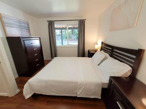 a bedroom with a large white bed and a window at Valleyview in Courtenay