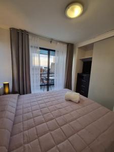 1 dormitorio con 1 cama grande y balcón en Departamento juan martines, en Iquique
