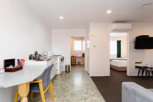 a kitchen and living room with a table and chairs at Highway Lodge Motel in Balclutha