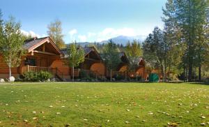 a log cabin with a lawn in front of it at Riverside Resort in Whistler