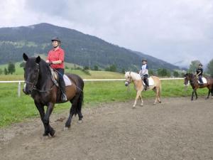 a group of people riding horses on a dirt road at Illusion in Flachau
