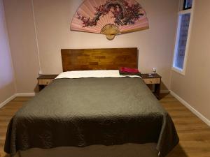 een slaapkamer met een groot bed met een houten hoofdeinde bij World's End Hostal in Puerto Natales