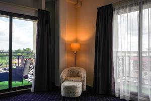 a room with a chair and a lamp and a window at Royal Breeze Paramaribo in Paramaribo