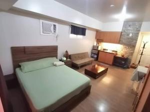 a bedroom with a large bed and a kitchen at Celadon Tower- Studio with balcony near SM San Lazaro in Manila