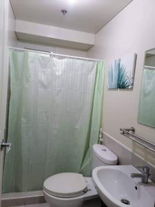een badkamer met een douche, een toilet en een wastafel bij Celadon Tower- Studio with balcony near SM San Lazaro in Manilla
