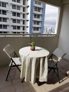 een tafel en stoelen in een kamer met een raam bij Celadon Tower- Studio with balcony near SM San Lazaro in Manilla