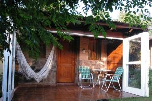 un porche de una casa con sillas y mesa en Cabañas Farah Estancia Vieja ideal para 2 a 4 huéspedes en Villa Carlos Paz