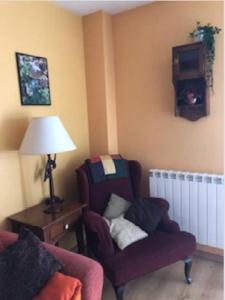 uma sala de estar com uma cadeira e um candeeiro em CHECK IN CASAS Casa Elson em Cerler