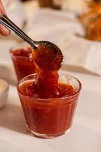 a spoonful of sauce in a cup on a table at Pousada Brilho da Serra in Tiradentes