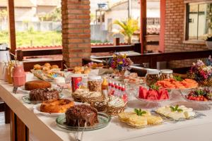 uma mesa com muitos tipos diferentes de alimentos sobre ele em Pousada Brilho da Serra em Tiradentes
