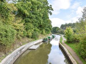 a river with several boats on it at Arun Cottage in Loxwood