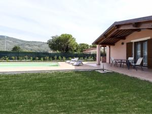 un patio trasero con piscina, mesa y sillas en Modern Villa with swimming pool in Spello, en Spello