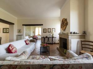 a living room with white couches and a fireplace at Private villa with swimming pool in the heart of Umbria in Bevagna